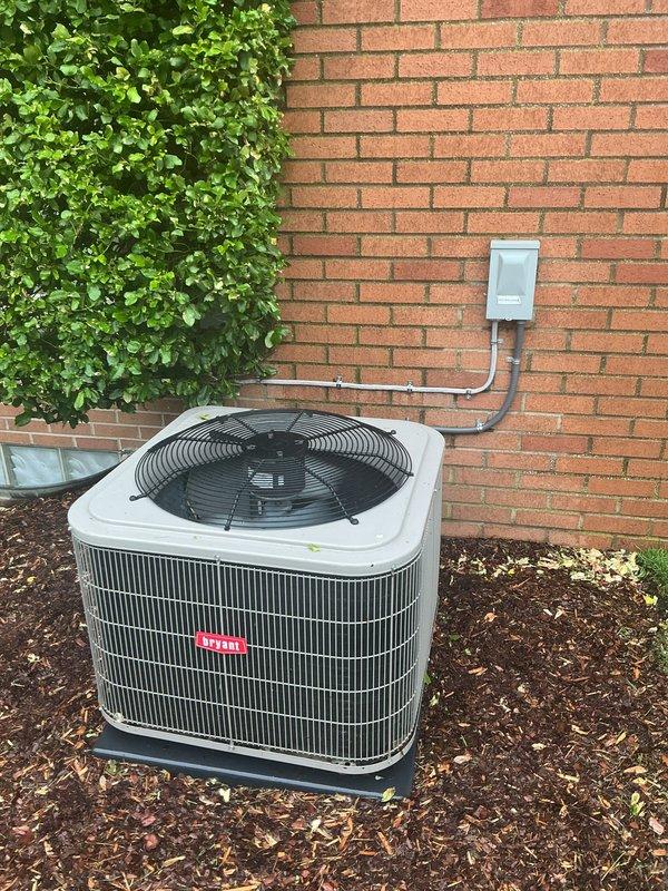 Completed comprehensive Gold AC inspection on 4-year-old residential air conditioning system with air handler located in basement. Performed thorough evaluation of outdoor condenser unit, including inspection of condenser coils, fan operation, refrigerant lines, and electrical disconnect. Verified proper clearance around unit, assessed landscaping proximity, and confirmed adequate airflow through condenser fins. Documented equipment condition through photographic records showing unit positioned on proper pad with appropriate mulch base and maintained surroundings. System found to be operational with no immediate service requirements identified during inspection.