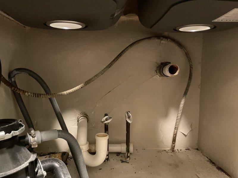 Completed installation of customer-provided kitchen faucet on double-basin stainless steel sink with chrome single-handle fixture mounted centrally on granite countertop. Inspected under-sink plumbing configuration including PVC P-trap assembly, garbage disposal connections, and flexible supply lines. Addressed customer concern regarding drain line leak connected to washing machine; verified all connections secure and functioning properly upon completion.