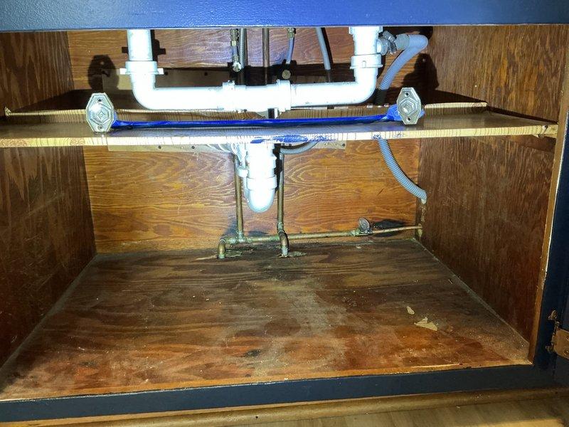Responded to a water leak under the kitchen sink affecting the cold water supply line, which had been shut off for approximately six months. Upon inspection, identified a failed cold water supply line connection requiring replacement. Removed the defective flexible supply line, installed a new braided stainless steel supply hose, and reconnected it to the shut-off valve and faucet assembly. Restored cold water service to the kitchen sink, tested all connections for proper operation and leaks, and verified adequate water pressure and flow. Cabinet floor showed evidence of previous water damage from the extended leak period. Documented pre-repair and post-repair conditions with photographs.