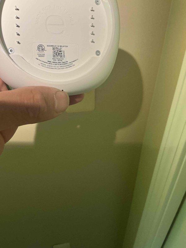 Responded to service call for an Ecobee thermostat that had gone blank with no display and lost access to heating and cooling system control. Upon arrival, removed the thermostat from the wall mount to inspect the unit and verify model information and manufacturing details. The 2-year-old unit showed no signs of power, indicating either a wiring issue, C-wire power supply problem, or internal component failure. Documented the thermostat's underside specifications and certification markings for warranty verification and potential replacement purposes.