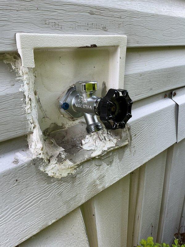 Responded to service call for leaking outdoor spigot mounted on exterior vinyl siding. Upon inspection, identified worn valve components causing water seepage. Removed existing chrome-plated brass spigot assembly from recessed mounting box and replaced with new frost-proof sillcock valve. Applied fresh weatherproof caulking around mounting box perimeter to ensure proper seal against exterior siding and prevent water infiltration behind wall. Verified all connections were secure, tested valve operation through multiple open/close cycles, and confirmed no leaks present under pressure. System restored to full functionality with improved weather protection.