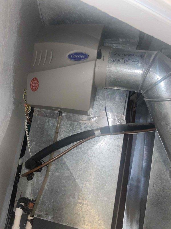 Responded to service call for thermostat malfunction where heating system operated normally but air conditioning would not activate. Conducted diagnostic assessment of 10+ year old AC system and existing thermostat of unknown age located in basement. Evaluated electrical panel configuration and circuit connections serving HVAC equipment. Inspected Carrier furnace unit and associated ductwork with seasonal damper controls in utility space. Documented existing equipment conditions and electrical service setup. Provided estimate for AC system replacement based on equipment age, operational failure of cooling function, and homeowner's service requirements.