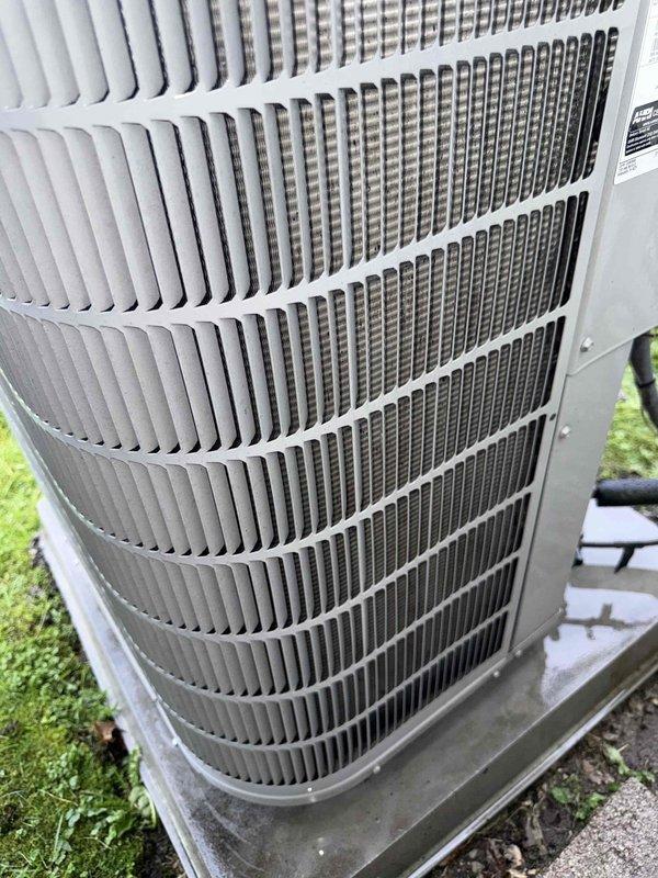Completed comprehensive Gold AC inspection on 10+ year old single-unit air conditioning system with outdoor condenser and basement-located air handler. System was operational at time of service. Performed thorough visual inspection of outdoor condenser unit, verifying proper clearance from structure, secure mounting on concrete pad, and structural integrity of cabinet and protective grilles. Examined condenser coil fins for alignment, cleanliness, and airflow obstruction—coils appeared clean with properly aligned fins and no visible damage or deterioration. Inspected exterior housing for rust, corrosion, or weather damage; unit showed typical outdoor weathering with no significant concerns. Verified manufacturer labeling was intact and legible. Assessed overall equipment condition and confirmed unit remains in serviceable condition with no immediate repairs required. System continues to operate as designed.