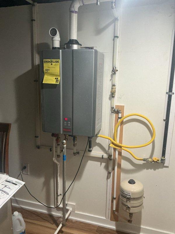 Completed comprehensive whole home plumbing inspection with particular emphasis on the tankless water heater system. Inspection revealed a professionally installed wall-mounted tankless unit with proper PVC exhaust venting, copper water supply lines, corrugated stainless steel gas line (CSST), and expansion tank. Verified all connections, mounting brackets, and support systems throughout the basement utility area including overhead PVC drainage lines, copper piping, and HVAC ductwork. Documented the condition of all plumbing infrastructure, pipe supports, and mechanical systems. All components were photographed for record-keeping purposes, with special attention given to the water heater installation as requested.