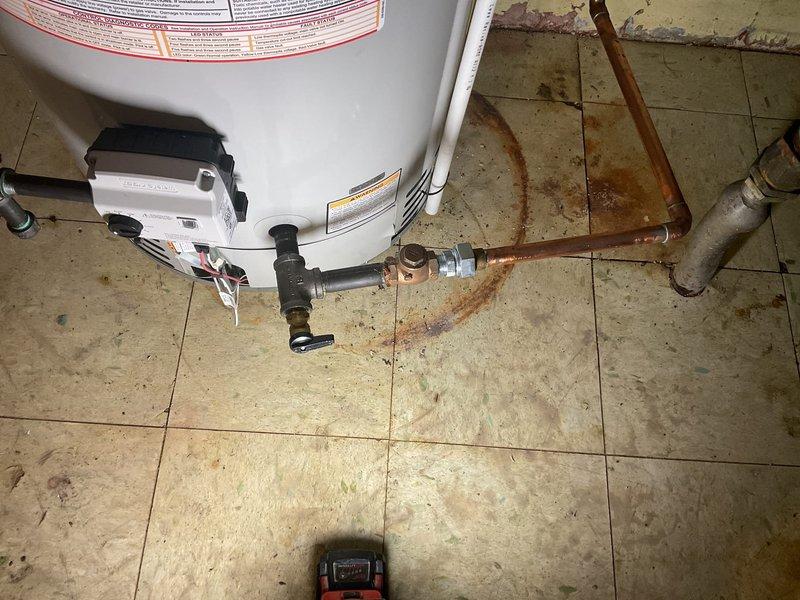 Corrected code violation on water heater recirculation system by removing non-compliant black iron pipe fittings and replacing with approved brass/galvanized nipples and fittings per P2906.5 and P2906.6 plumbing code requirements. Reconnected existing recirculation line to water heater with code-compliant materials for proper water distribution system operation.