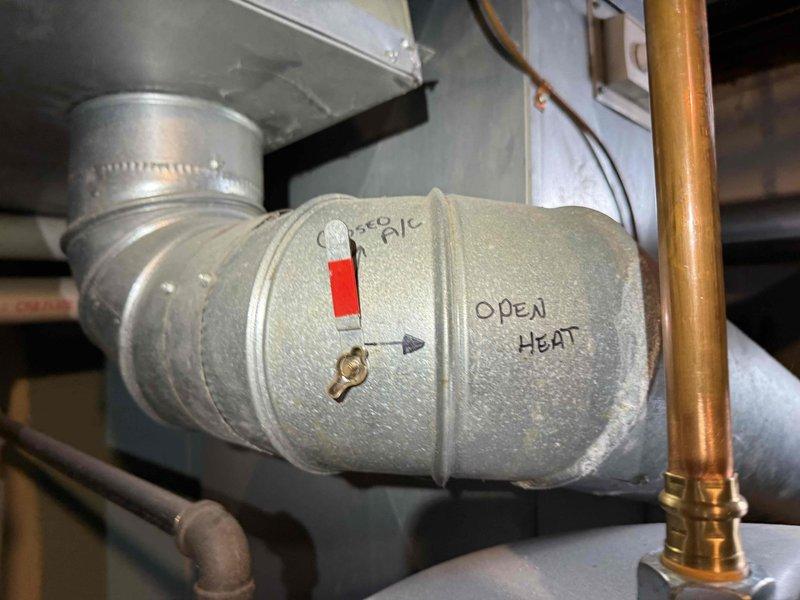 Completed prepaid maintenance visit on 15-year-old air conditioning system with outdoor condenser unit and basement evaporator coil. Inspected outdoor condenser unit, which showed normal weathering and surface dirt accumulation consistent with age; verified fan operation and checked refrigerant levels. Examined basement mechanical components including motorized damper assembly and associated ductwork connections. System operational at time of service with no immediate repairs required.