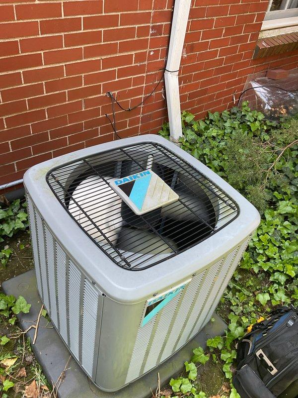 Completed comprehensive Gold AC inspection on 6-year-old residential air conditioning system with outdoor condenser unit and basement-located air handler. Performed multi-point inspection including visual assessment of condenser cabinet condition, refrigerant line connections, electrical components, and condensate management system. Unit confirmed operational at time of service. Noted exterior cabinet showing weather-related discoloration and vegetation growth around perimeter requiring attention for optimal airflow and longevity. Documented all equipment conditions and component configurations through photographic records for maintenance history.