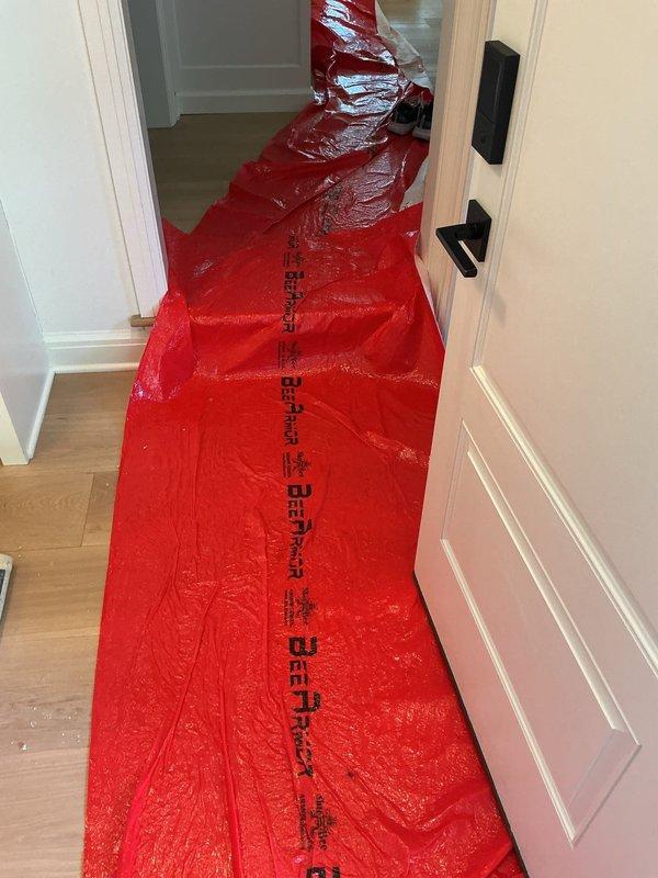 Responded to a drain cleaning service call at a residential property. Upon arrival, installed protective red plastic floor runners throughout the interior hallway and staircase to prevent damage to light wood-tone flooring and carpeted stairs during service. Successfully cleared the clogged drain/sink using standard drain cleaning equipment and techniques. All protective materials were properly placed to maintain cleanliness of the work area throughout the service call. Homeowner confirmed satisfactory resolution of the drainage issue upon completion.
