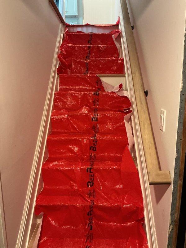 Responded to a drain cleaning service call at a residential property. Upon arrival, installed protective red plastic floor runners throughout the interior hallway and staircase to prevent damage to light wood-tone flooring and carpeted stairs during service. Successfully cleared the clogged drain/sink using standard drain cleaning equipment and techniques. All protective materials were properly placed to maintain cleanliness of the work area throughout the service call. Homeowner confirmed satisfactory resolution of the drainage issue upon completion.