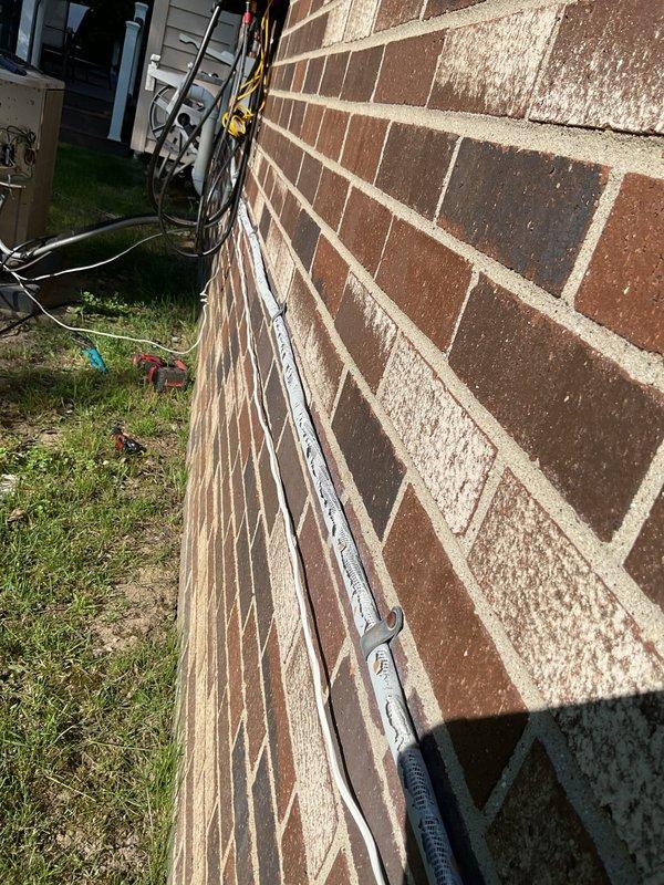 Completed installation of a 3.5-ton air conditioning unit with matching evaporator coil in the rear yard location. System was professionally mounted on brick exterior, all electrical connections and refrigerant lines were properly installed and secured with appropriate conduit and cable management, and unit was successfully reconnected and tested for proper operation.