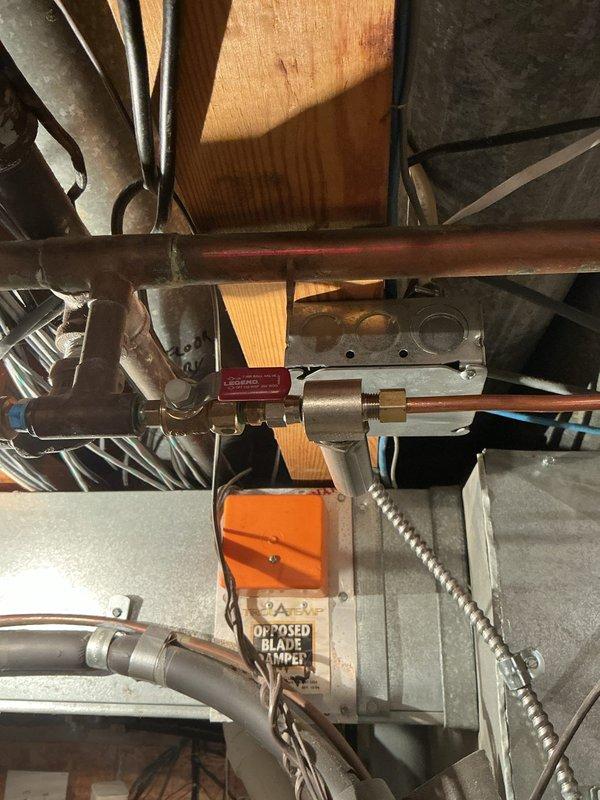 Installed shut off valve and cap for humidifier water supply line in basement mechanical room. Connected brass valve to existing copper piping near HVAC system to provide isolation capability for humidifier maintenance and winterization. All connections tested and verified leak-free upon completion.