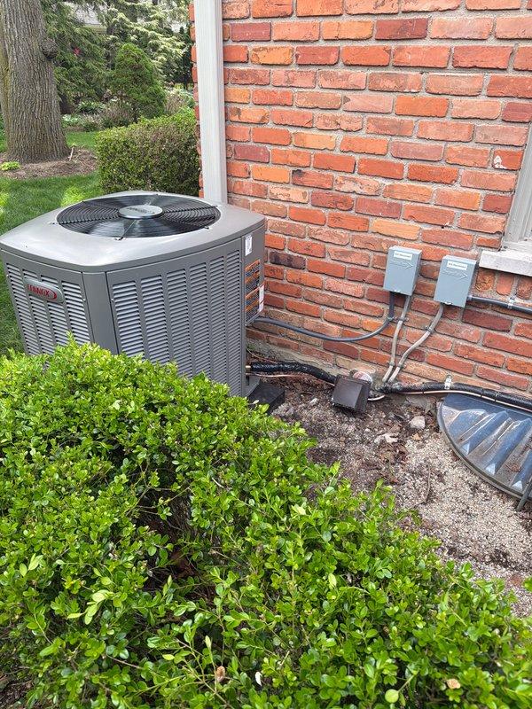 Completed installation of 3-ton air conditioning system with evaporator coil on second floor left side of residence. Installed Lennox condenser unit on exterior concrete pad with proper refrigerant line connections, electrical disconnect boxes, and conduit routing along brick exterior. System was fully charged, tested for proper operation, and reconnected to existing ductwork in mechanical room.