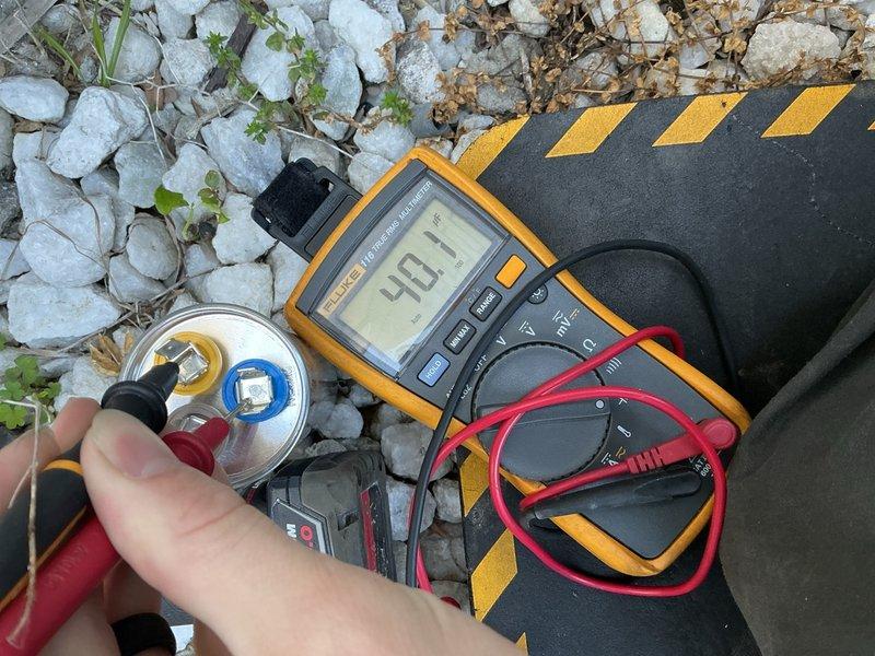 Completed comprehensive Gold AC inspection on a residential single-unit air conditioning system over 10 years old with air handler located in basement. System was operational upon arrival and verified to be functioning properly throughout the inspection process.

Performed thorough evaluation of outdoor condensing unit, including visual inspection of cabinet condition, fan motor operation, and compressor performance. Utilized digital multimeter to measure electrical parameters, recording voltage and current readings to verify proper system operation. Tested and evaluated run capacitor to ensure adequate electrical storage capacity for compressor and fan motor startup, confirming values within manufacturer specifications at 49.1 microfarads.

Inspected basement air handler and evaporator coil assembly, examining surrounding plumbing infrastructure including water heater installation and copper piping systems. Noted presence of aged copper pipes with visible oxidation and patina, along w