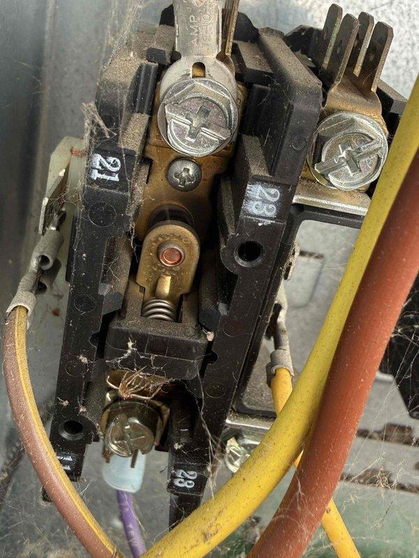 Completed Gold AC Inspection on 10+ year old Bryant air conditioning system with air handler located in basement. Performed comprehensive visual inspection of outdoor condensing unit positioned on concrete pad. Examined electrical contactor assembly, noting accumulated dirt and debris consistent with equipment age. Inspected contactor terminals, mechanical linkages, and wiring connections for proper operation and integrity. Evaluated outdoor unit condition including protective grille, manufacturer labeling, and overall cabinet weathering. Assessed installation site including concrete pad stability and surrounding landscaping clearances. Documented equipment condition through photographic records. Unit confirmed operational at time of inspection. All inspection items completed per Gold maintenance protocol specifications.