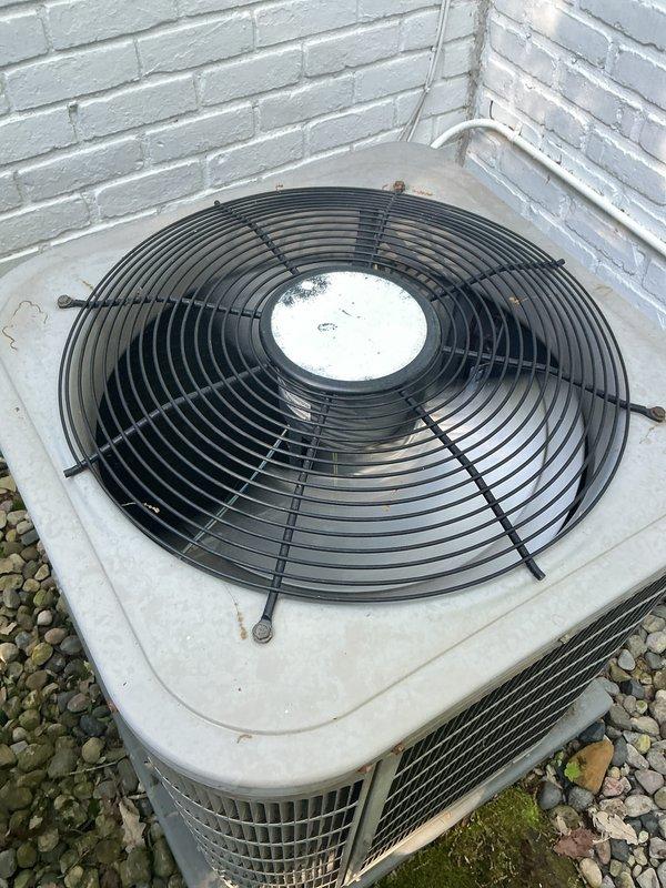 Completed comprehensive Gold AC inspection on 10+ year old residential air conditioning system with air handler located in basement. Outdoor condenser unit found operational with functional fan assembly and motor, though showing age-appropriate weathering and surface dirt accumulation. Advised customer to maintain clear area around condenser unit, removing any debris and animal waste to ensure proper airflow and system efficiency.