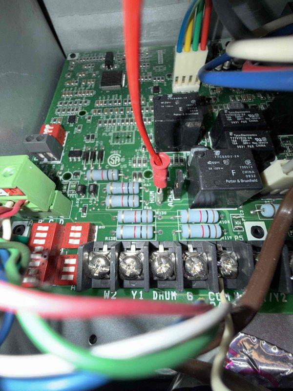 Responded to no cooling call on 17-year-old air conditioning system located in basement. Unit would not restart after shutting off during night, with amber indicator light remaining illuminated. Upon inspection, diagnosed failed control board as cause of system lockout. Control board showed signs of age-related component failure, preventing proper system operation and communication with compressor and blower components. Documented existing equipment condition including control board wiring connections, capacitor assembly, and refrigerant line configuration for service records.