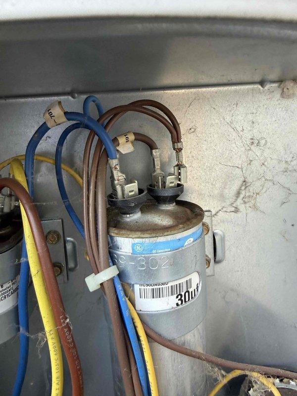 Responded to no cooling call on 17-year-old air conditioning system located in basement. Unit would not restart after shutting off during night, with amber indicator light remaining illuminated. Upon inspection, diagnosed failed control board as cause of system lockout. Control board showed signs of age-related component failure, preventing proper system operation and communication with compressor and blower components. Documented existing equipment condition including control board wiring connections, capacitor assembly, and refrigerant line configuration for service records.