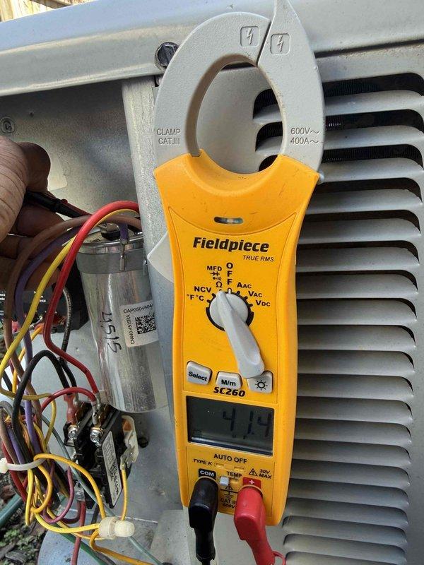 Completed comprehensive Gold AC inspection on 8-year-old residential air conditioning system with outdoor condensing unit and basement air handler. Performed visual inspection of exterior condensing unit, verified proper placement on pad, checked refrigerant line connections and condensate drainage system. Conducted electrical diagnostics using clamp meter to test amperage draw, verified capacitor ratings at 45/5 MFD, inspected all electrical connections and wiring for proper operation. System found to be operating within normal parameters with no immediate service needs identified.