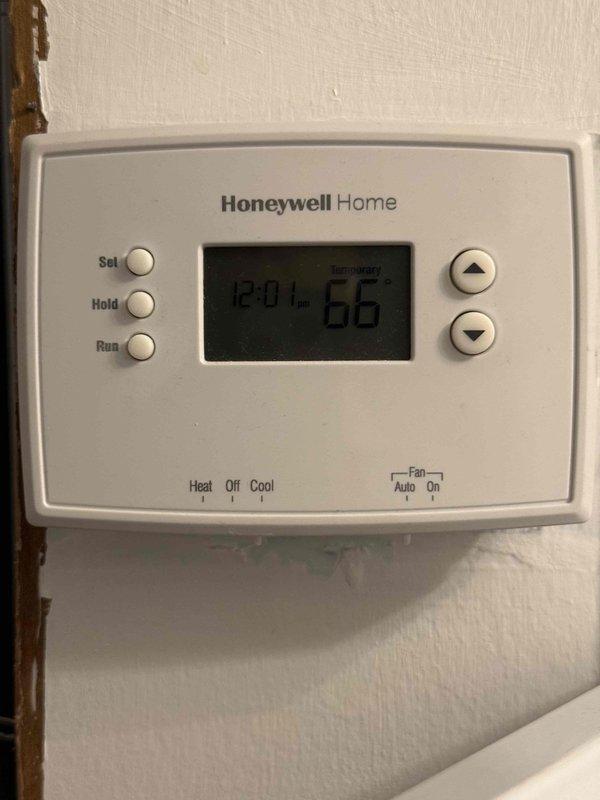 Responded to service call for intermittent banging noise emanating from blower motor area when air conditioning system operates. Upon arrival, inspected 15-year-old outdoor condensing unit and recently installed furnace with air handler. System was operational and providing adequate cooling with no refrigerant leaks, visible damage, or abnormal odors detected. Verified thermostat functionality and observed air handler with clean filter in place. Documented equipment condition through photographs of thermostat and air handler assembly for reference, as noise was not actively occurring during inspection period.