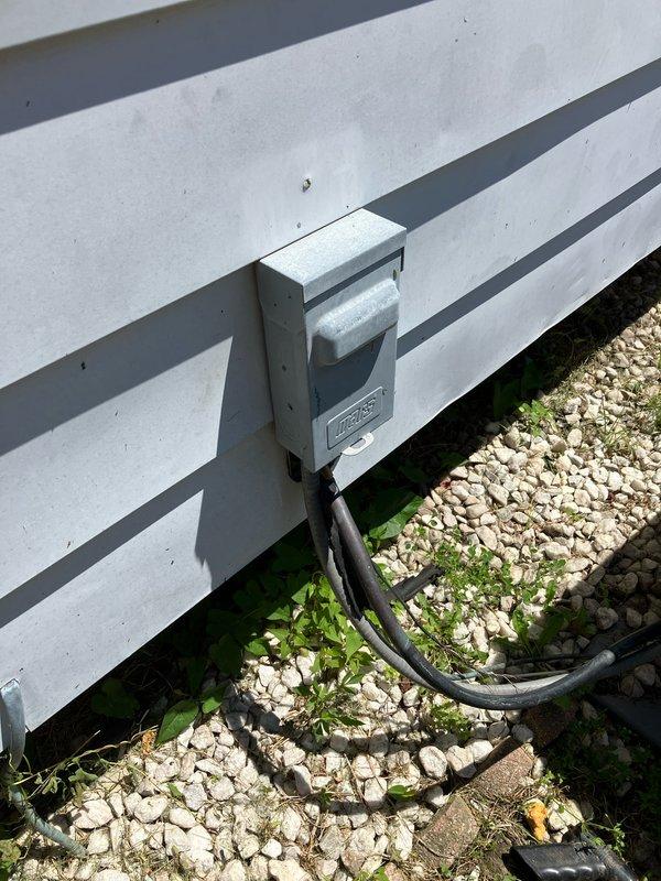 Conducted comprehensive site evaluation for complete HVAC system replacement of 20-year-old equipment with existing furnace located in basement and outdoor condensing unit positioned on concrete pad adjacent to building exterior. Documented current system configuration including electrical disconnect box, conduit routing, and equipment placement for accurate replacement specifications. Photographed existing outdoor unit installation, foundation conditions, and electrical service connections to prepare detailed replacement estimate.