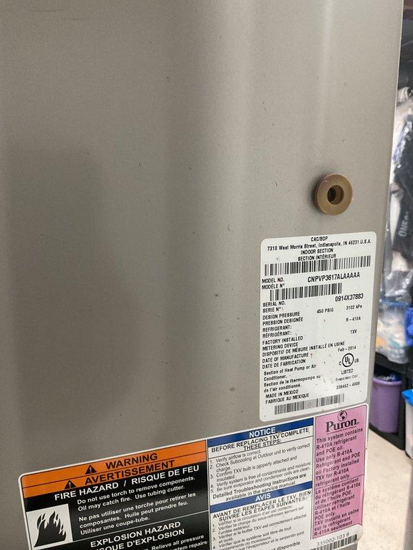 Completed non-service plan air conditioning inspection on a 10-year-old residential cooling system with air handler located in basement. Unit was operational at time of inspection, exterior condenser showed normal wear consistent with age, and all accessible components were documented through photographic records including manufacturer data plate showing R-410A refrigerant specifications and model information.