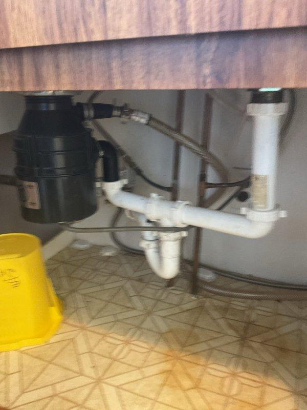Completed plumbing repair quote for kitchen sink drainage system and associated basement plumbing connections. Assessed existing white PVC trap configuration, garbage disposal installation, flexible supply lines, and basement plumbing infrastructure including galvanized metal piping and vertical PVC drainage system. Customer approved quoted repair work estimated at 2-3 hours for completion.