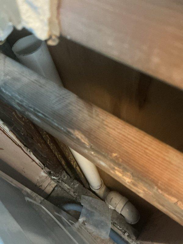 Responded to a washing machine drain line backup issue caused by slow drainage in a previously modified plumbing system. Upon arrival, inspected the basement plumbing infrastructure where the homeowner had previously cut and re-piped the capped main drain line. Identified a blockage located approximately one to two feet within the drainage pipe that was preventing proper water flow and causing backup conditions.

Examined the PVC drain line connections, including elbow joints and transitions to older metal plumbing components showing significant corrosion. Assessed the plumbing configuration in the confined utility area, noting the convergence of multiple pipe sizes and the condition of existing connections. Cleared the obstruction from the drain line to restore proper flow rate and eliminate the backup issue. Verified drainage system functionality to ensure water now flows freely through the washing machine drain without restriction. Documented existing plumbing conditions including c
