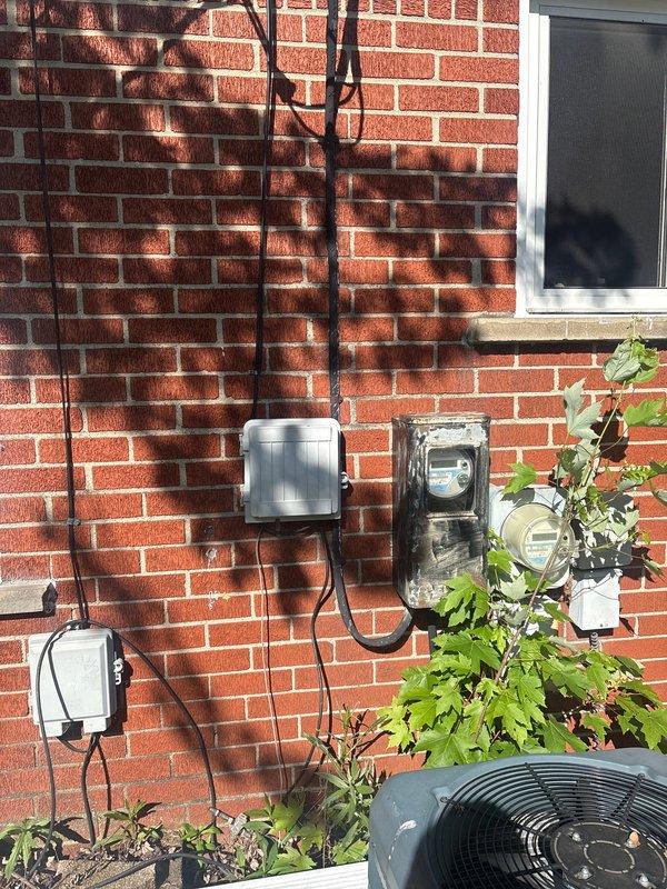 Responded to service call regarding circuit breaker producing abnormal noise. Upon arrival, conducted comprehensive inspection of main electrical panel and service entrance equipment. Examined exterior meter base, weatherproof disconnect box, and associated conduit connections mounted on building exterior. Inspected overhead service drop cables and their connection points at the soffit for signs of arcing, loose connections, or deterioration. Evaluated main panel interior for loose breaker connections, overheating indicators, and proper wire terminations. Identified source of audible noise, performed necessary corrections to eliminate hazard, and verified all connections were secure and functioning within normal parameters. System tested and confirmed operational.