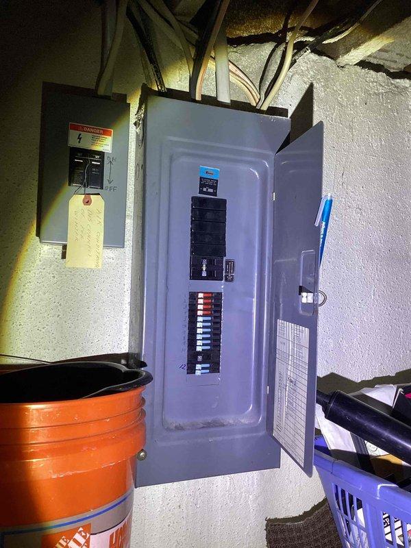 Conducted comprehensive assessment of 41-year-old air conditioning system installed in 1985 and located in basement. Documented existing air handler unit with compromised condensate drain pan experiencing active leakage, rendering equipment inoperable. Evaluated white cabinet-style air handling unit with PVC condensate drainage system, flexible ductwork connections, and associated electrical service panel. Photographed current system configuration including condensate piping with blue bands, metal ductwork, electrical breaker panel, and overall equipment placement for replacement estimate documentation. Provided detailed whole-home AC replacement quote for owner-occupied residence requiring complete system upgrade due to equipment age and failure of critical components.