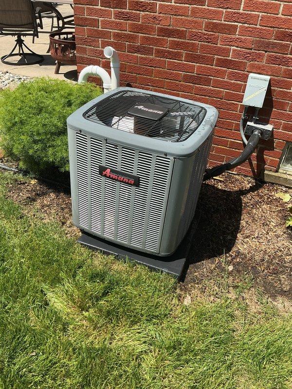 Completed comprehensive Gold AC inspection on 8-year-old Amana condensing unit located on exterior concrete pad. Performed multi-point system evaluation including visual inspection of condenser cabinet, fan grille, refrigerant line connections, electrical disconnect box, and condensate drain piping. Unit found in operational condition with proper airflow through louvers, secure mounting on pad, and adequate clearances from structure. Verified PVC condensate line routing and confirmed electrical connections at disconnect box. System operating as designed with no immediate service requirements identified during inspection.