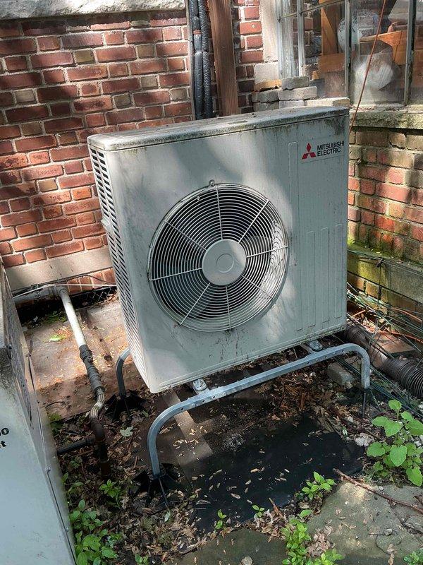 Completed comprehensive tune-up maintenance on three residential AC units over 10 years old located in basement, kitchen, and attic areas. Serviced one Mitsubishi outdoor condensing unit and one Carrier outdoor condenser, both showing signs of age and environmental wear. Performed standard preventative maintenance procedures including cleaning condenser coils, checking refrigerant levels, inspecting electrical connections, testing capacitors, lubricating motors where applicable, replacing air filters, and verifying proper operation of all three systems. Noted vegetation growth and debris accumulation around exterior units; cleared immediate area around condensers to ensure adequate airflow. Exterior units displayed weathering consistent with age but remained operational. All refrigerant lines, electrical connections, and mounting hardware inspected and found secure. Tested system performance and verified proper cooling operation across all three zones. Recommended ongoing seasonal main