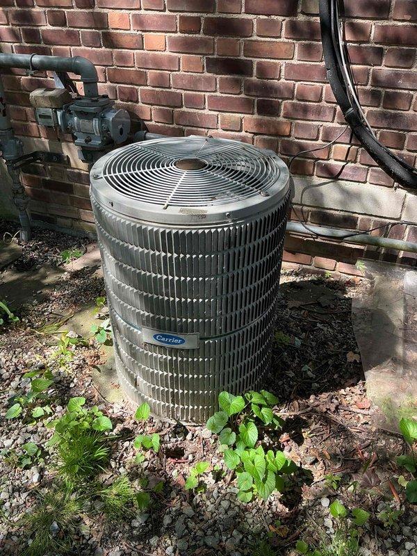 Completed comprehensive tune-up maintenance on three residential AC units over 10 years old located in basement, kitchen, and attic areas. Serviced one Mitsubishi outdoor condensing unit and one Carrier outdoor condenser, both showing signs of age and environmental wear. Performed standard preventative maintenance procedures including cleaning condenser coils, checking refrigerant levels, inspecting electrical connections, testing capacitors, lubricating motors where applicable, replacing air filters, and verifying proper operation of all three systems. Noted vegetation growth and debris accumulation around exterior units; cleared immediate area around condensers to ensure adequate airflow. Exterior units displayed weathering consistent with age but remained operational. All refrigerant lines, electrical connections, and mounting hardware inspected and found secure. Tested system performance and verified proper cooling operation across all three zones. Recommended ongoing seasonal main