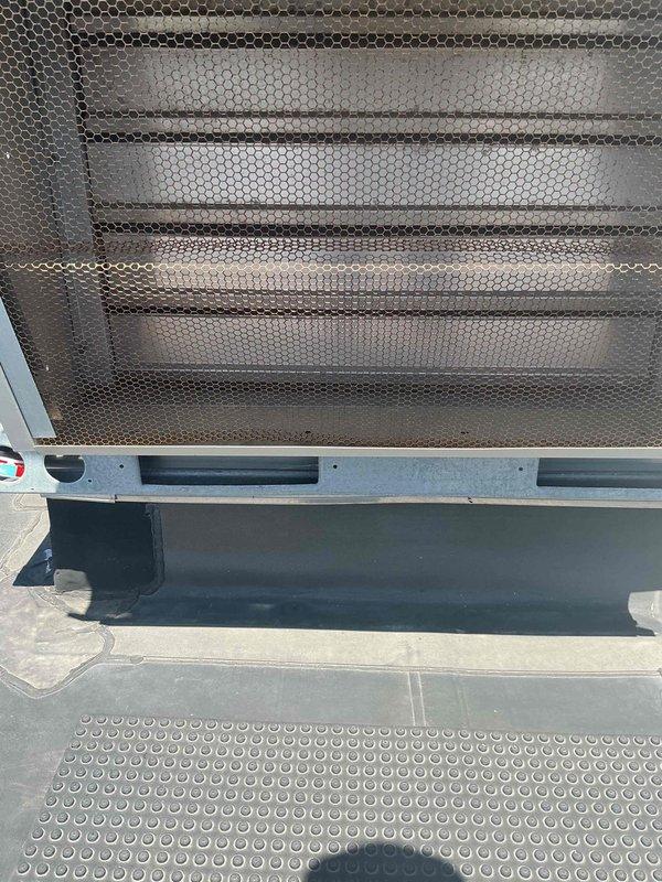 Responded to commercial facility for complaints of excessive noise from HVAC system and building pressure imbalance causing doors to blow open when units cycle. Inspected two rooftop units (RTUs) and performed diagnostic testing on electrical components and refrigerant systems. Used digital multimeter to verify proper voltage and amperage across contactors, relays, and control modules. Identified issues with system airflow balance affecting building pressurization. Examined interior components including copper refrigerant lines, valves, and air handling sections with perforated grilles. Completed electrical measurements and documented equipment conditions for both roof-mounted and ceiling units.