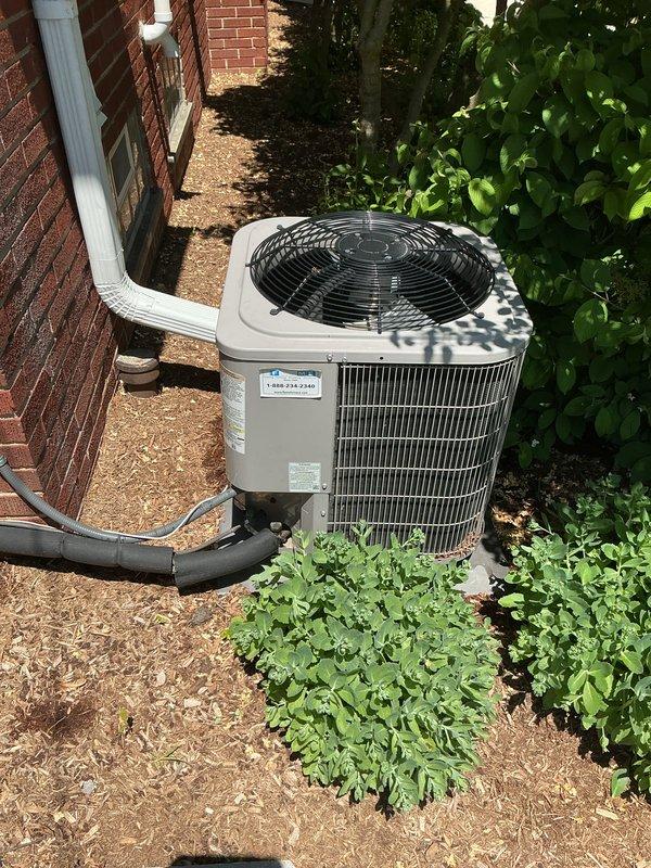 Completed Gold AC Inspection on 4-year-old single-zone residential air conditioning system with air handler located in basement. Performed comprehensive maintenance inspection including visual assessment of outdoor condensing unit, refrigerant line connections, and overall system operation. 

Addressed customer concern regarding condenser unit settlement and slope deterioration since installation. Inspected unit positioning on mulch bed alongside brick exterior, noting condensing unit placement and ground conditions. Evaluated structural stability, refrigerant line routing along exterior wall, and proper drainage considerations. Photographically documented current condenser positioning, surrounding landscape conditions, and unit installation configuration for future reference.

Verified system operational status, inspected condenser coil fins, fan assembly with protective grille, and electrical connections. Confirmed proper refrigerant line insulation and secure mounting to building ex