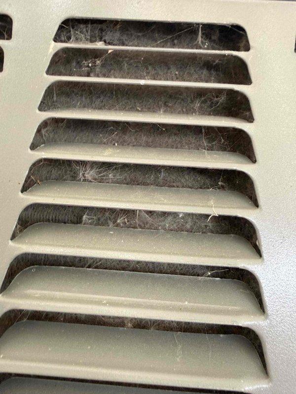 Completed comprehensive AC tune-up and cooling system maintenance on residential air conditioning unit. Performed standard inspection protocol including refrigerant level check, electrical connection testing, condenser coil cleaning, and air filter evaluation. Documented significant dust and debris accumulation on supply and return air vents with photographic evidence; noted heavy buildup of lint, cobwebs, and airborne particles restricting proper airflow through register grilles. System confirmed operational and cooling properly upon completion of maintenance procedures.