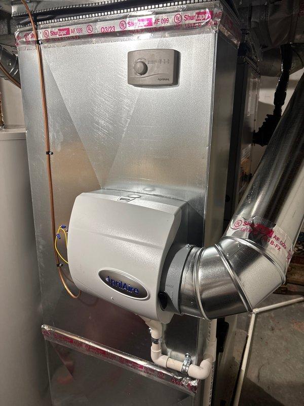Completed full HVAC system installation including a 90,000 BTU furnace and 2.5-ton Lennox air conditioning unit with rear discharge configuration. Installed Aprilaire humidifier integrated into the ductwork system with proper water supply connections via PVC piping. Mounted outdoor condenser on concrete pad with electrical disconnect, ran refrigerant lines, and installed new thermostat for system control. All mechanical and electrical permits obtained prior to installation, and system was fully tested and operational upon completion.
