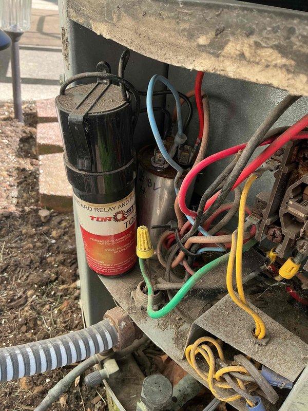 Completed comprehensive Gold AC inspection on a 9-year-old single-zone residential air conditioning system with air handler located in basement. Unit was operational at time of service. Performed thorough examination of outdoor condenser unit, including inspection of hard start relay and capacitor assembly, verified all electrical connections and wiring integrity, and assessed overall system condition. Documented equipment status with photographic evidence showing exterior components, control mechanisms, and unit placement on concrete pad adjacent to structure.