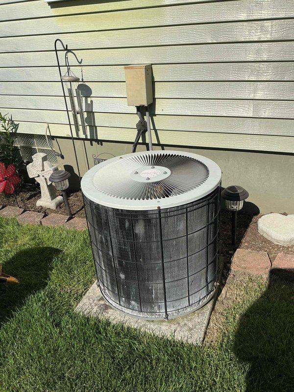 Completed comprehensive Gold AC inspection on a 9-year-old single-zone residential air conditioning system with air handler located in basement. Unit was operational at time of service. Performed thorough examination of outdoor condenser unit, including inspection of hard start relay and capacitor assembly, verified all electrical connections and wiring integrity, and assessed overall system condition. Documented equipment status with photographic evidence showing exterior components, control mechanisms, and unit placement on concrete pad adjacent to structure.