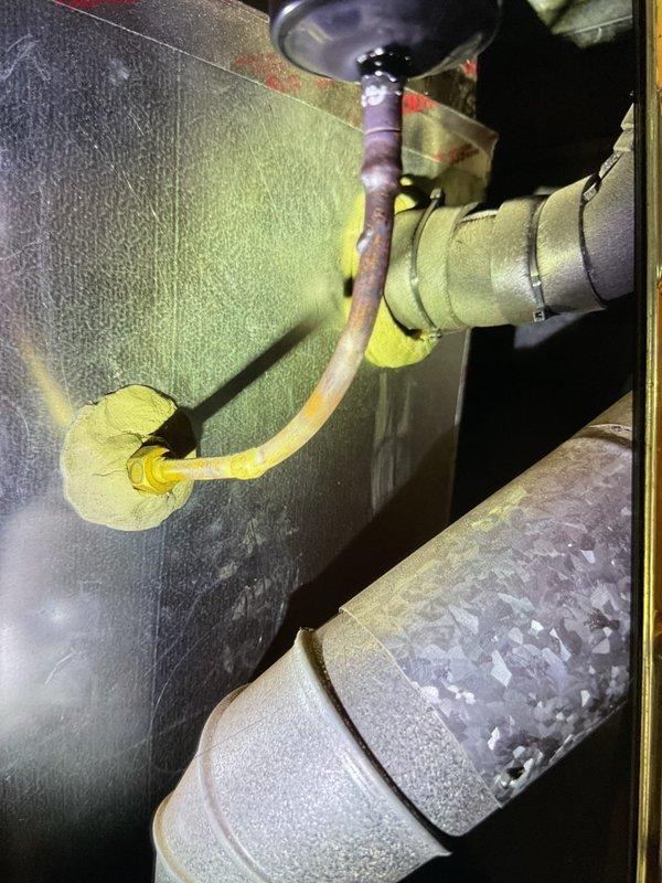 # HVAC Maintenance - Gold AC Inspection

Completed comprehensive Gold AC inspection on 6-year-old residential cooling system with air handler located in basement. Performed thorough evaluation of both indoor and outdoor equipment components per maintenance protocol.

Inspected outdoor condenser unit positioned on concrete pad against exterior wall. Verified fan assembly operation, examined casing integrity, and assessed overall unit condition. Condenser exhibited normal weathering consistent with age but maintained functional status with no structural damage to cabinet or fan grille.

Conducted detailed examination of basement air handler and associated mechanical components. Evaluated insulated ductwork, refrigerant line sets, and system connections. Documented significant corrosion and oxidation on copper refrigerant piping, showing deterioration with rust patches and discoloration ranging from dark brown to exposed copper. Corrosion noted at pipe joints and fittings, indicating pote