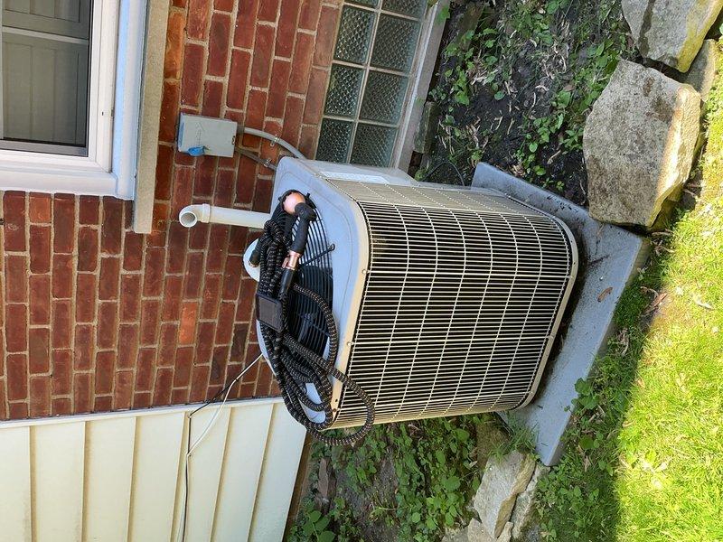 Completed comprehensive Gold AC inspection on 15-year-old residential cooling system. Performed thorough examination of basement-located evaporator coil and blower motor assembly, checking all electrical connections, wire harnesses, and motor mounting integrity. Inspected outdoor condenser unit, evaluating condenser coil condition, refrigerant lines, and overall system operation. Documented equipment condition through photographic records showing blower motor wiring configuration and exterior condenser placement on concrete pad adjacent to building foundation. All components assessed for age-appropriate wear and operational status.