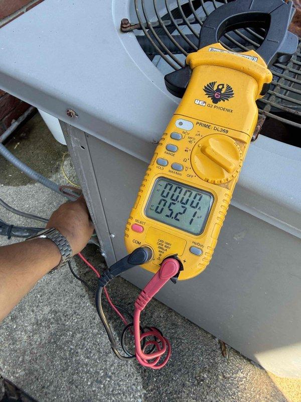 Responded to service call for 20-year-old A/C unit in basement experiencing unusual noises and overheating issues. Performed diagnostic testing using digital clamp meter on condenser unit, recording electrical readings of 280.0 amps and 0.52 voltage parameters. Conducted borescope inspection of internal components, revealing significant rust and corrosion on heat exchanger tubing and ductwork, consistent with age-related deterioration affecting system performance and causing reported operational concerns.