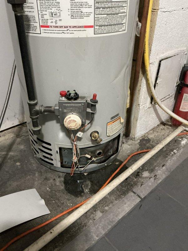Responded to service call for leaking water heater in basement utility area. Upon inspection, found existing 40-gallon residential tank-style water heater with active leak at base and visible water damage on concrete floor surrounding unit. Water supply had been shut off to unit prior to arrival. Assessed unit for potential repairs but determined leak originated from tank failure, rendering unit non-repairable. Provided estimate for replacement and received approval to proceed with same-day installation.

Removed failed water heater and prepared installation area. Installed new 40-gallon residential gas-fired tank water heater in same location. Connected cold water supply line and hot water outlet using appropriate copper piping and fittings. Installed temperature and pressure relief valve with proper discharge piping termination. Connected existing gas line using flexible gas connector with yellow coating, ensuring all connections met code requirements. Verified proper venting configu