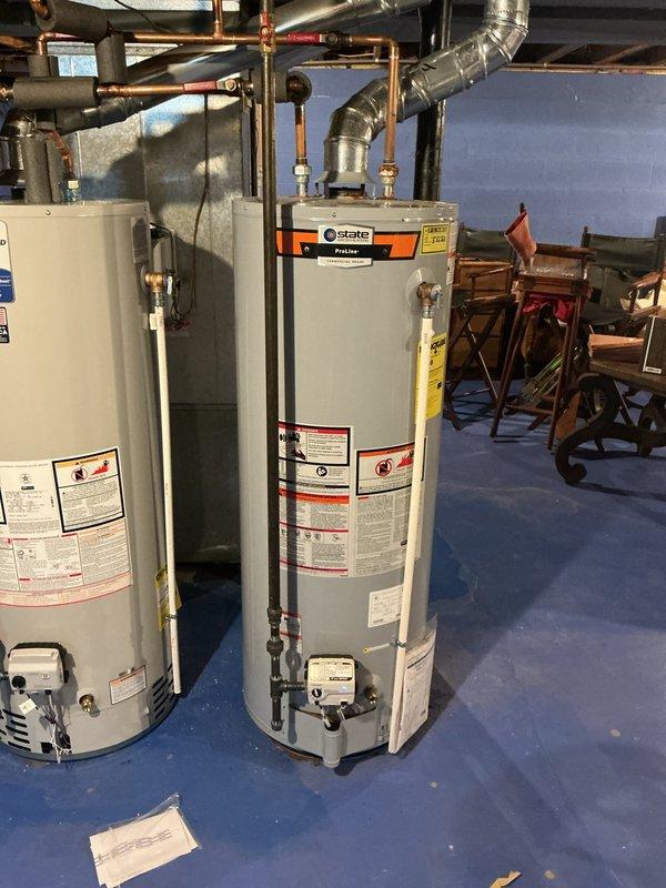 Replaced failed State brand tanked water heater that was leaking and compromised under existing 10-year warranty coverage. Documented model and serial numbers of both existing units with photographs, as one unit had previously been replaced with a Bradford White model. Installed new warranted replacement water heater with proper connections to existing copper supply lines, ensuring all plumbing connections, pressure relief valve, and control systems were properly configured and tested for operation.