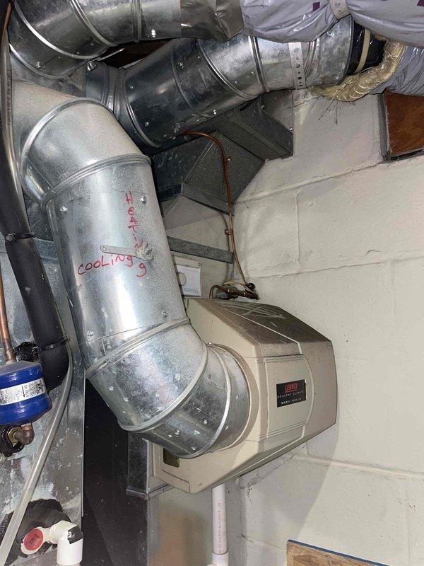 Conducted comprehensive site assessment for complete HVAC system replacement in owner-occupied residence. Evaluated existing 21-year-old air conditioning unit located in basement mechanical room, documenting current system configuration including heat pump ductwork, humidifier component, and associated ventilation infrastructure. Photographed equipment layout, ductwork routing, and basement conditions to develop accurate replacement quote for whole system upgrade.