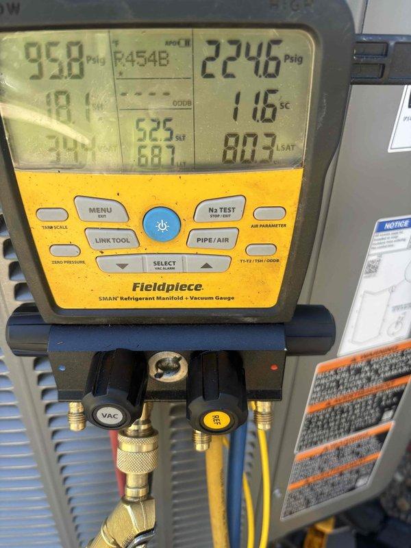 Completed air conditioning system start-up for basement evaporator coil installation. Verified proper unit leveling, checked refrigerant pressures and temperatures using digital manifold gauges, and confirmed system operation with readings of 95.8 psig low side and 224.6 psig high side with 116°F superheat measurement.