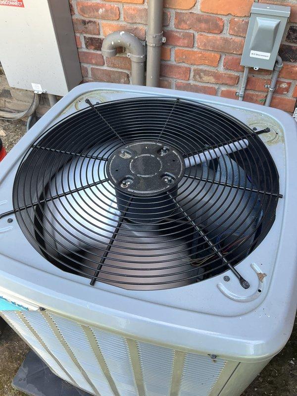 Completed routine summer air conditioning tune-up on a 2-3 year old system with indoor unit located in basement and outdoor condenser unit positioned against exterior brick wall. Performed comprehensive maintenance inspection including cleaning condenser coils, checking refrigerant levels, testing electrical connections, verifying proper airflow through fan assembly, and inspecting condensate drain lines. System operating within normal parameters with no issues identified; unit showing typical outdoor weathering but functioning properly for continued reliable cooling performance.