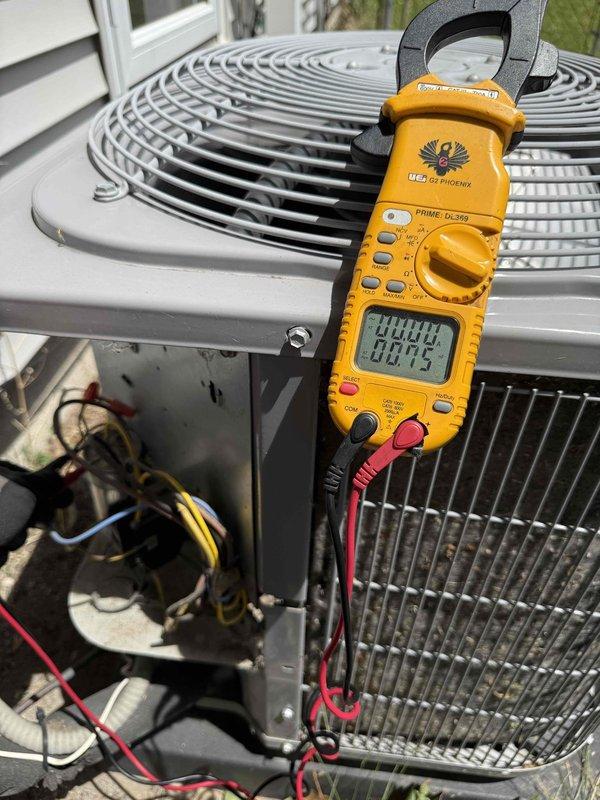 Responded to no cooling complaint on 10+ year old air conditioning system. Upon arrival, found outdoor condensing unit running but not providing adequate cooling. Performed visual inspection revealing heavily soiled condenser coil with significant debris accumulation restricting airflow through fins. Measured compressor amperage at 88.75 amps using clamp meter to verify electrical operation. Accessed electrical panel to inspect capacitor, contactor, and wiring connections. Condenser coil required thorough cleaning to restore proper heat transfer and system efficiency. Unit operational at time of service with blower circulating air but cooling capacity compromised due to restricted condenser airflow from dirt buildup.