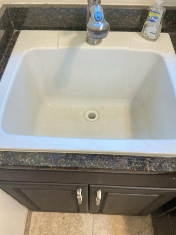 Responded to active leak under kitchen sink in 26-year-old residential property. Upon inspection, identified compromised connection at garbage disposal drain assembly and deteriorated P-trap seal causing water intrusion into cabinet base. Disassembled existing drain configuration, replaced P-trap assembly with new PVC components, and re-secured disposal discharge connection with proper gasket seal. Tested all connections under full water pressure to verify leak elimination. Additionally, installed new quarter-turn shutoff valves in basement to replace original gate valves showing age-related wear. All plumbing fixtures tested and confirmed operational with no additional leaks detected throughout property.