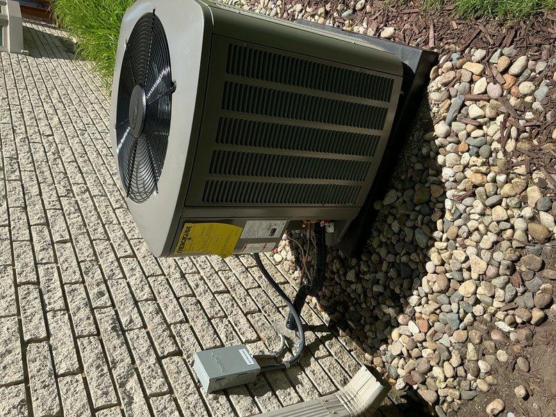 Completed full HVAC system installation including a 70,000 BTU furnace and 2.5 ton rear-discharge air conditioning unit. Installed S40 thermostat, 500M humidifier, condensate pump, and performed system flush. Obtained mechanical, plumbing, and electrical permits for the installation. Reconnected all utilities, verified proper operation of all components, and documented AHRI reference number 215663829 for equipment matching certification. System qualified for utility rebate programs and was photographed showing the outdoor condenser unit properly positioned on concrete pad with appropriate clearances and landscaping.