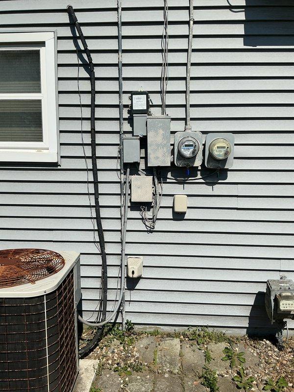 Performed estimate for air conditioning system replacement at residential property. Unit evaluated showed failing contactor and low R22 refrigerant levels, with equipment age exceeding 10 years. Outdoor condenser unit located on concrete pad adjacent to house with evaporator coil installed in basement. System inadequately cooling living space due to component failure and refrigerant loss in aging equipment operating on phased-out R22 refrigerant. Documented existing installation with exterior condenser mounted on weathered concrete pad with electrical service running along exterior wall to main service panel. Provided comprehensive replacement options and recommendations for modern high-efficiency system upgrade with updated refrigerant technology.